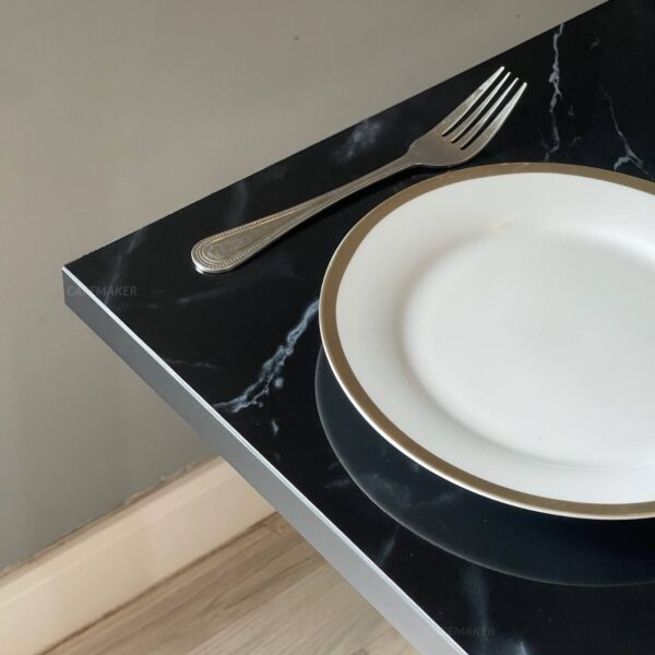 Close-up of black marble table with round golden leg