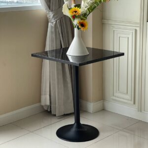 Black marble table with elegant leg, featuring a beautiful flower arrangement on top
