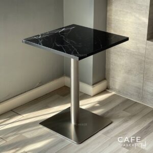 Isometric view of a black marble table featuring sturdy metal leg, highlighting its modern design