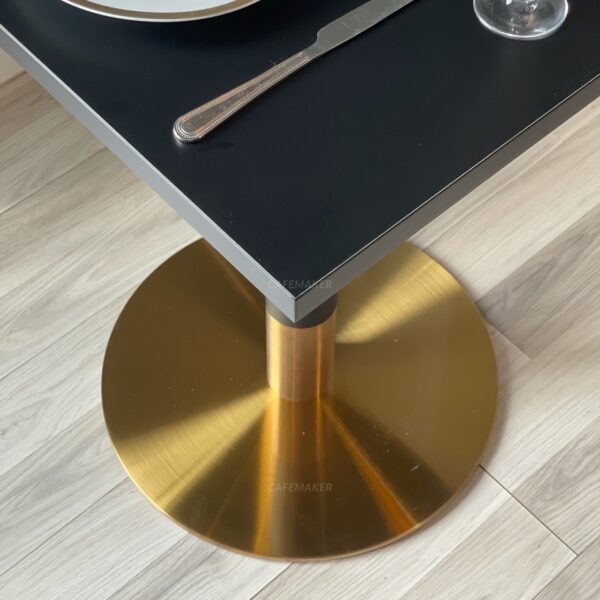 base of a black top table with black and golden leg