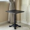 Isometric view of a black top table with Roman-style legs