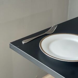 Close-up view of a black top table with golden leg
