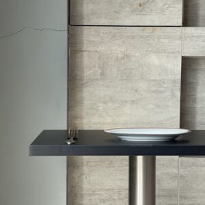 Top side view of a black top table with metal leg