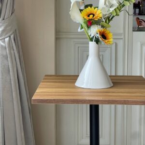 Oak top table with round leg, beautifully adorned with a flower arrangement on top
