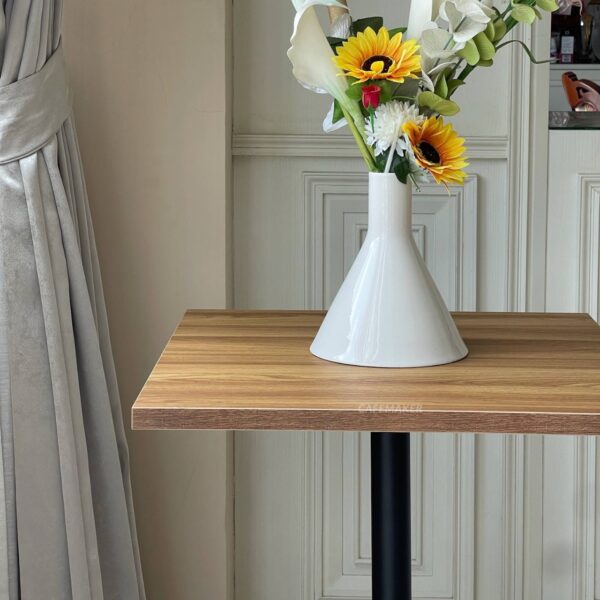 Oak top table with round leg, beautifully adorned with a flower arrangement on top