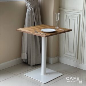 Oak top table with square white leg, styled as a prop in a modern decor setting