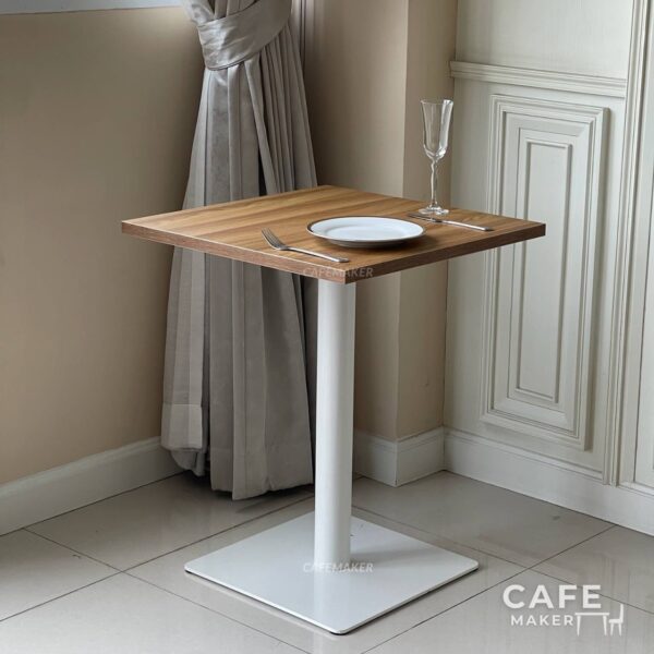 Oak top table with square white leg, styled as a prop in a modern decor setting
