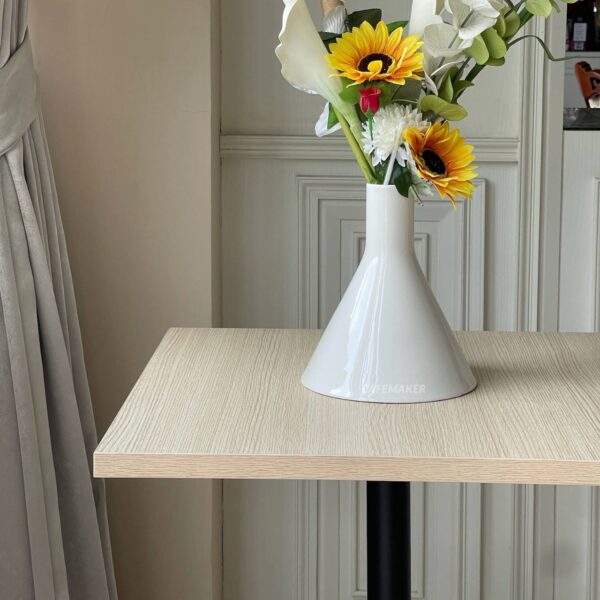 Parawood top table with round leg, beautifully adorned with a flower arrangement on top