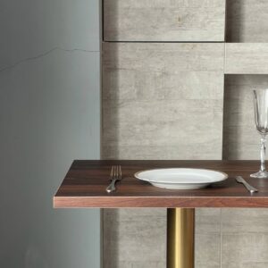 Top side view of a walnut top table featuring elegant golden leg