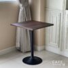 Isometric view of a walnut top table featuring round leg, showcasing its rich grain and stylish design