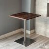 Isometric view of a walnut top table featuring sleek metal leg