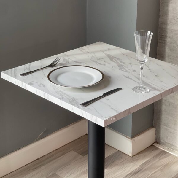 Top view of a white marble table featuring black and gold leg, showcasing its elegant design