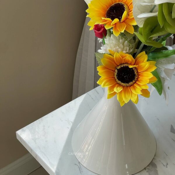 White marble table with ornate Roman leg, featuring a beautiful flower arrangement on top