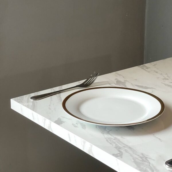 Close-up of white marble table with round golden leg