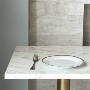Top side view of a white marble table featuring golden leg