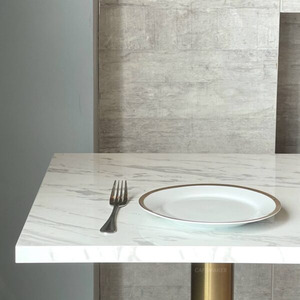 Top side view of a white marble table featuring golden leg