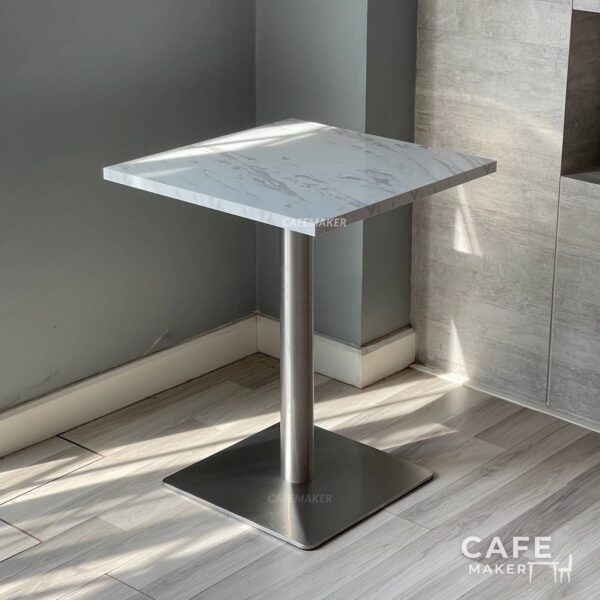 Isometric view of a square white marble table featuring sturdy metal legs, highlighting its modern design