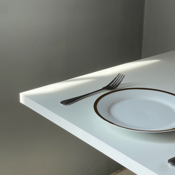 Close-up of a white table with white metal leg