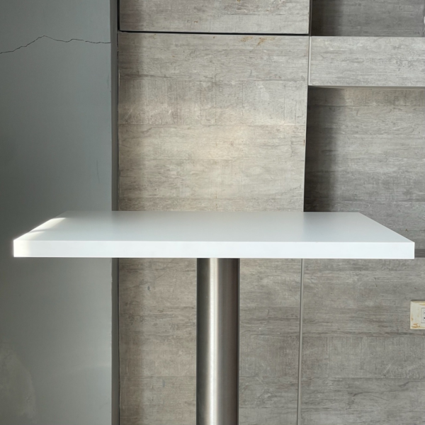 Square table with white top and metal leg, side view