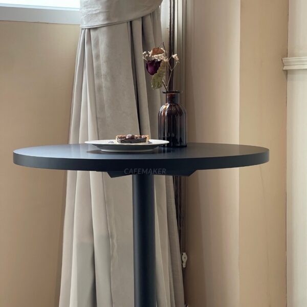 Side view of a black-top round table with round leg