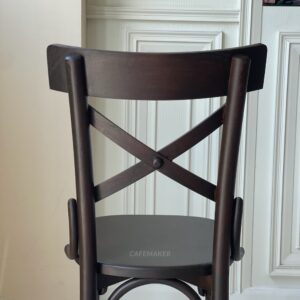 Back view of a narrow black parawood Windsor chair, showcasing its traditional spindle backrest design