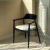 Isometric view of a black parawood side chair with a thick backrest