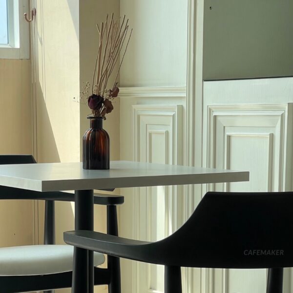 Close-up view of a set of black parawood side chairs with thick backrests