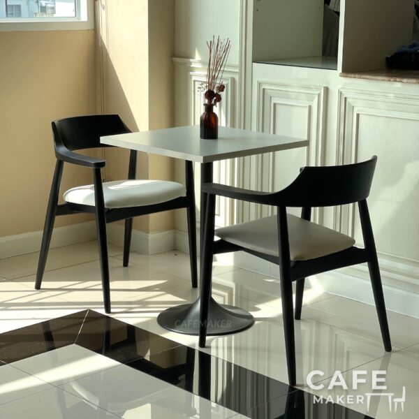 Set sample of black parawood side chairs with thick backrests arranged in a modern display