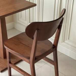 Isometric back view of a walnut parawood café chair featuring a C-Curved backrest