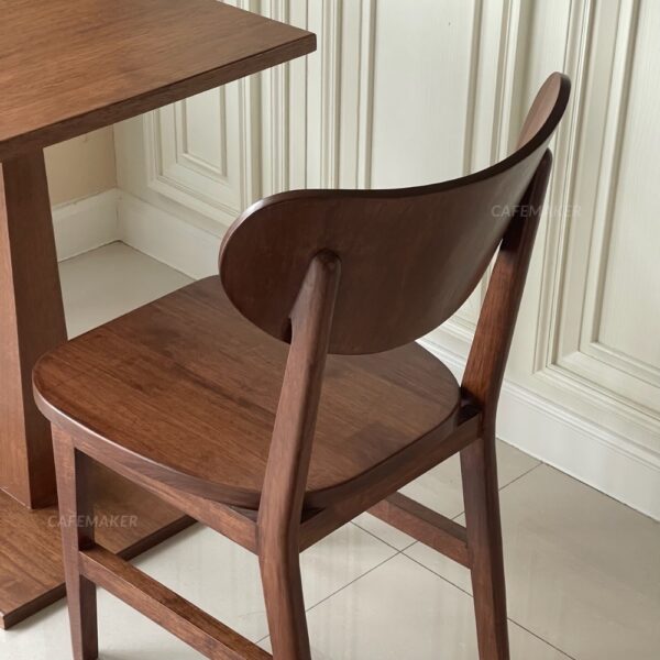 Isometric back view of a walnut parawood café chair featuring a C-Curved backrest