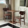 Walnut parawood café chair with a curved backrest displayed in a set arrangement