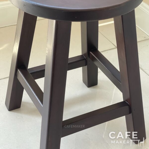 Close-up view of a walnut parawood round stool chair showcasing its texture and craftsmanship