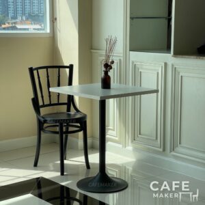 Set sample of wide black parawood Windsor chairs arranged together in a stylish display