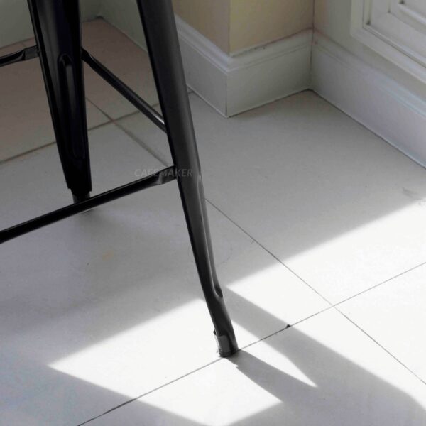 Close-up view of a black metal stool leg