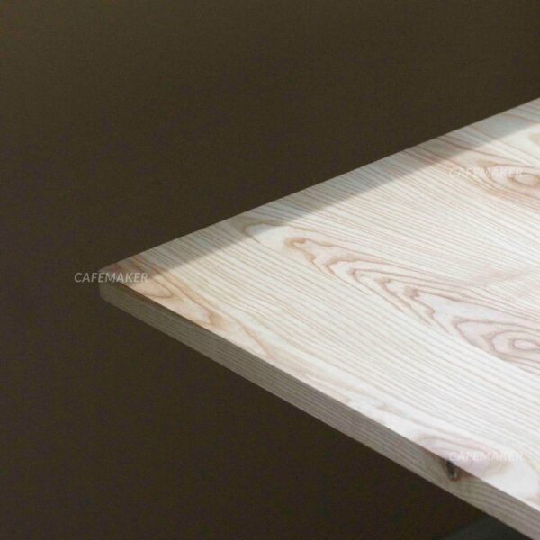 Close-up view of an ashwood top table with square metal leg