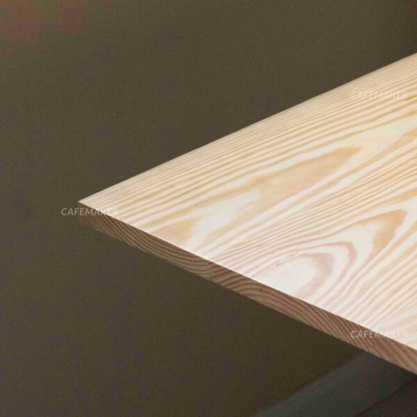 Close-up view of a pine top table with white square leg