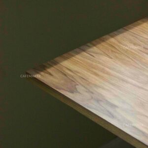 Close-up view of a walnut top table with champagne leg