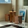 natural plywood dining set with round table and backless chairs styled with props
