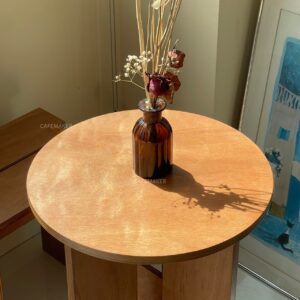 top close-up of natural plywood dining set showing round tabletop and chair seats