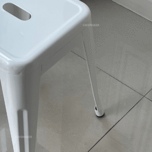 close-up view of white metal stool chair showing surface texture and finish